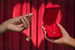 someone trading a locket for a diamond necklace