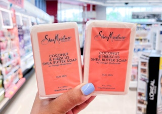 hand holding two bars of SheaMoisture coconut & hibiscus shea soap bars in aisle