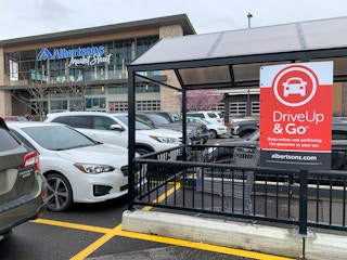 Albertsons Drive Up & Go grocery pickup sign in front of the store.