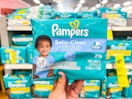 hand holding a pack of pampers baby clean baby wipes