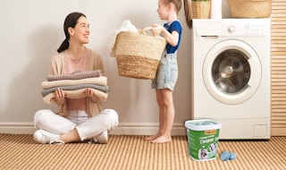 A girl and mom sitting near a washing machine