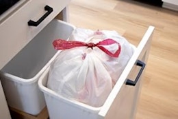 Full trash bag inside trash bin