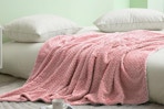 pink throw blanket draped across a bed