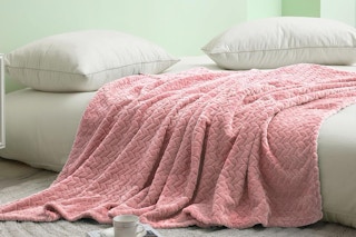 pink throw blanket draped across a bed