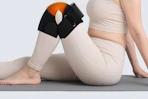 a woman using a knee massager