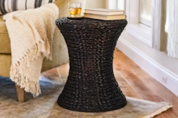 Lifestyle image of the dark stain  Hyacinth hour glass table in home setting (near a window)