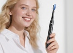 a person holding an electric toothbrush