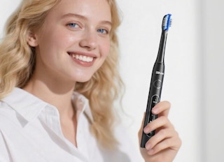 a person holding an electric toothbrush