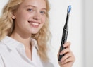 a person holding an electric toothbrush