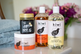 Kiwi botanicals, body wash and body conditioner with a jar of Manuka Honey on a counter.