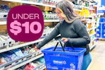 model grabbing lotion out the travel essentials are holding a Walmart basket