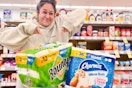 person standing over bounty and charmin paper products pointing at them