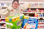 person standing over bounty and charmin paper products pointing at them