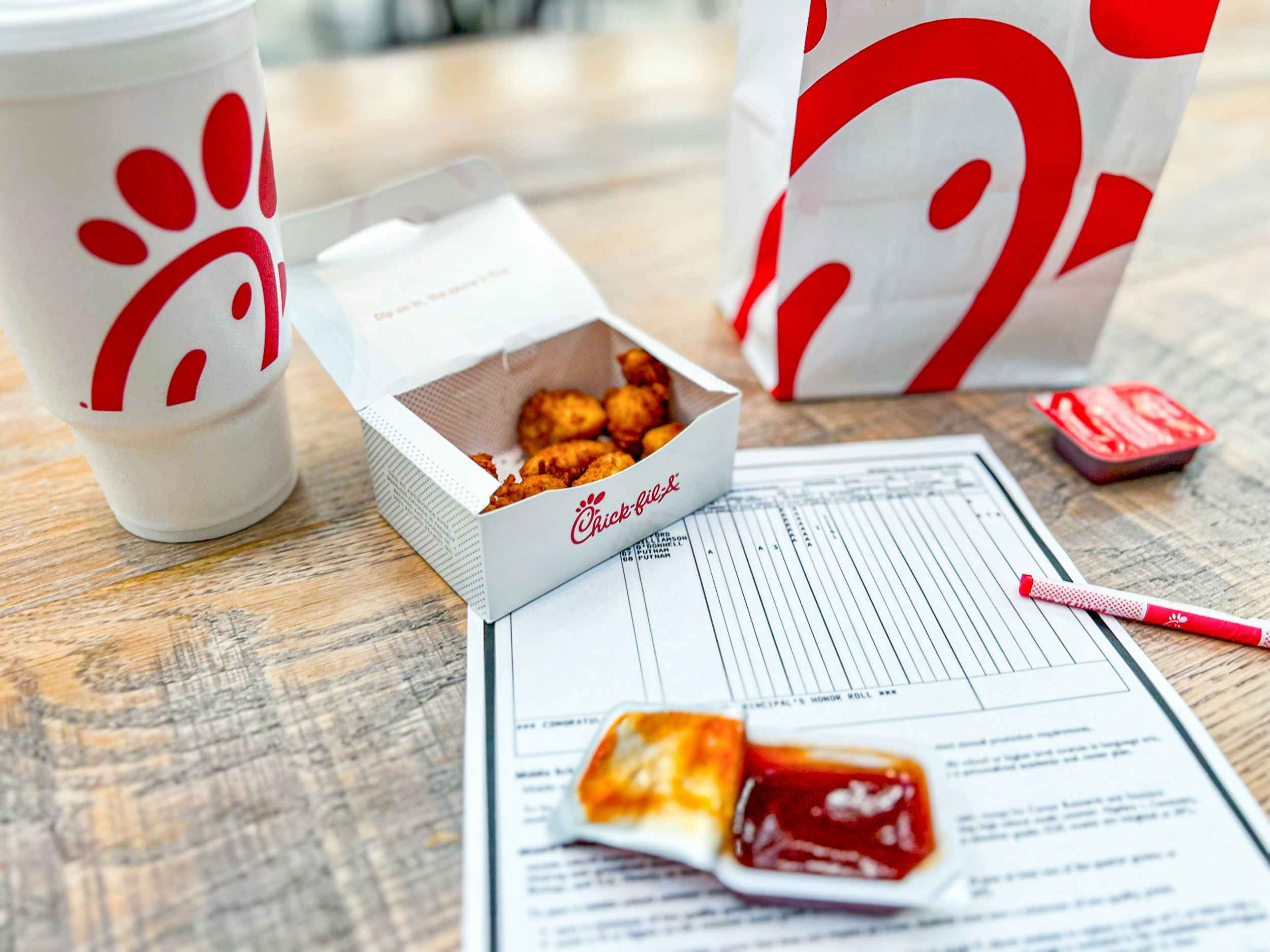 chick fil a nuggets next to a child's report card