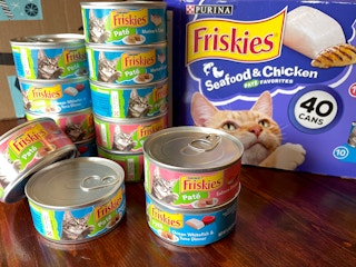 Friskies cat food stacked up on a table