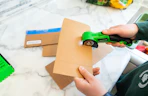a person using an electric box cutter on cardboard