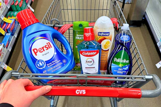 person pushing a cart with persil detergent, garnier shampoo, colgate mouthwash, softsoap body wash, and palmolive dish soap in it