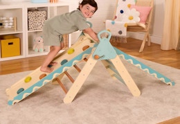 child climbing a wooden climber
