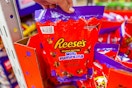 hand holding a bag of reeses mini pumpkins