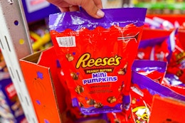 hand holding a bag of reeses mini pumpkins