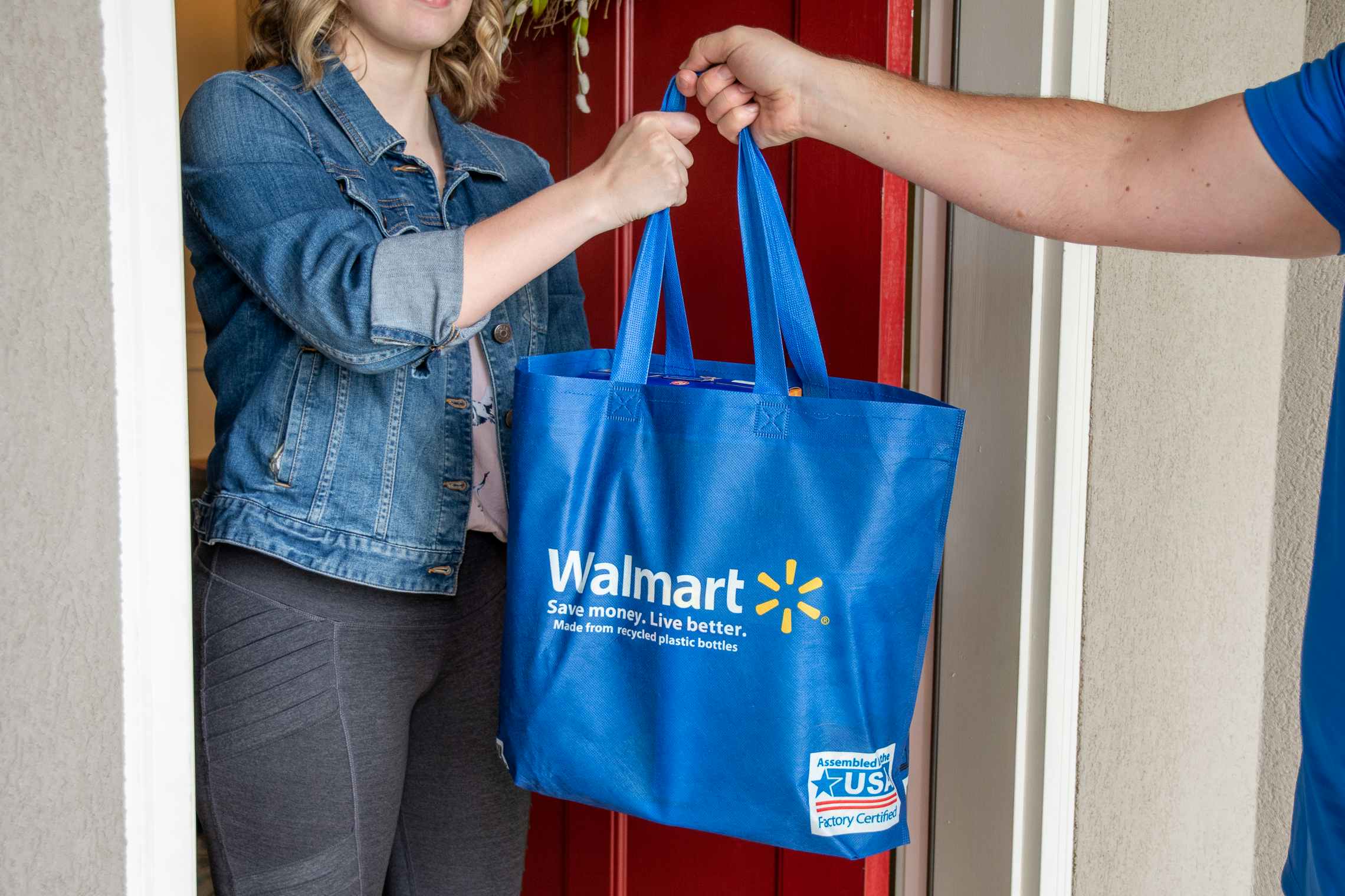 A person receiving a Walmart delivery at their front door.