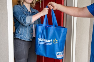 A person receiving a Walmart delivery at their front door.