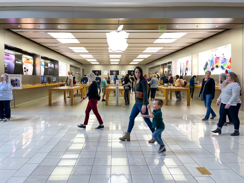 Apple store, store front with people walking buy.