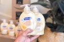 hand holding Softsoap milk and honey bottles