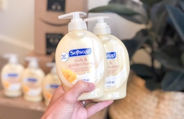 hand holding Softsoap milk and honey bottles