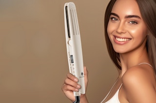 Woman holding a Hair straightener.