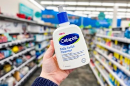 person holding a bottle of cetaphil cleanser in an aisle