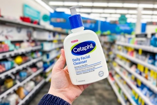 person holding a bottle of cetaphil cleanser in an aisle