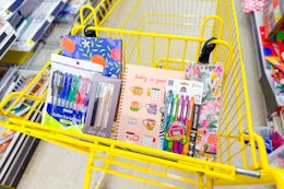 journals and pens in a yellow shopping cart