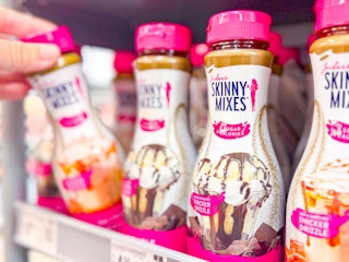 hand holding a bottle of skinny mixes with other bottles on walmart shelf