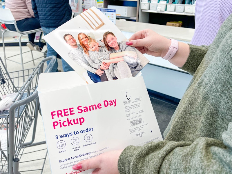 A woman holding Walgreens photo packet and an 8x10 print