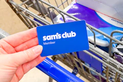 hand holding a sams club membership card over cart