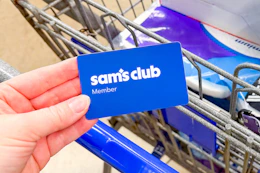hand holding a sams club membership card over cart