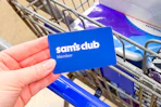 hand holding a sams club membership card over cart
