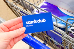 hand holding a sams club membership card over cart