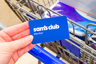 hand holding a sams club membership card over cart