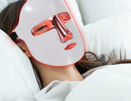 a person with a red light therapy face mask on 