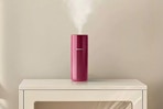 Homedics Portable Ultrasonic Humidifier in the color "Berry" on a piece of furniture