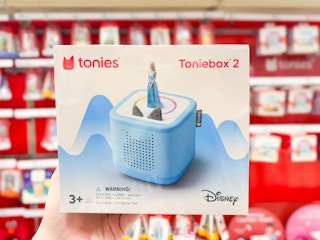 hand holding a tonies toniebox 2 starter kit in front of target shelf