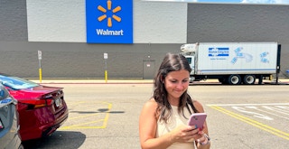 a person looking at their phone outside of walmart