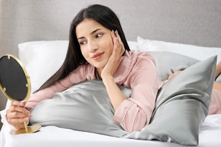 Woman laying on satin pillowcase.