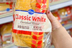 hand holding a loaf of kroger bread