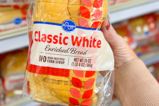 hand holding a loaf of kroger bread