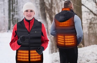 a couple outside wearing a heated vest in the snow