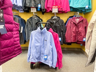 Variety of Columbia jackets hanging from store racks and from a shopping cart.