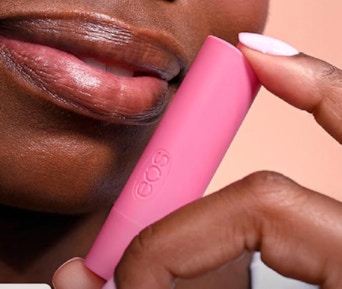 a person holding a lip balm tube 